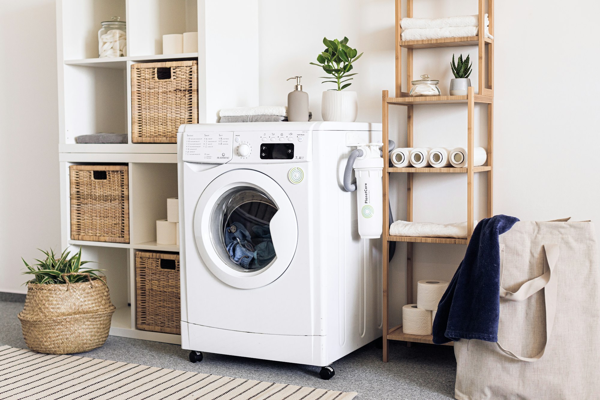 A white washing machine beside a laundry basket