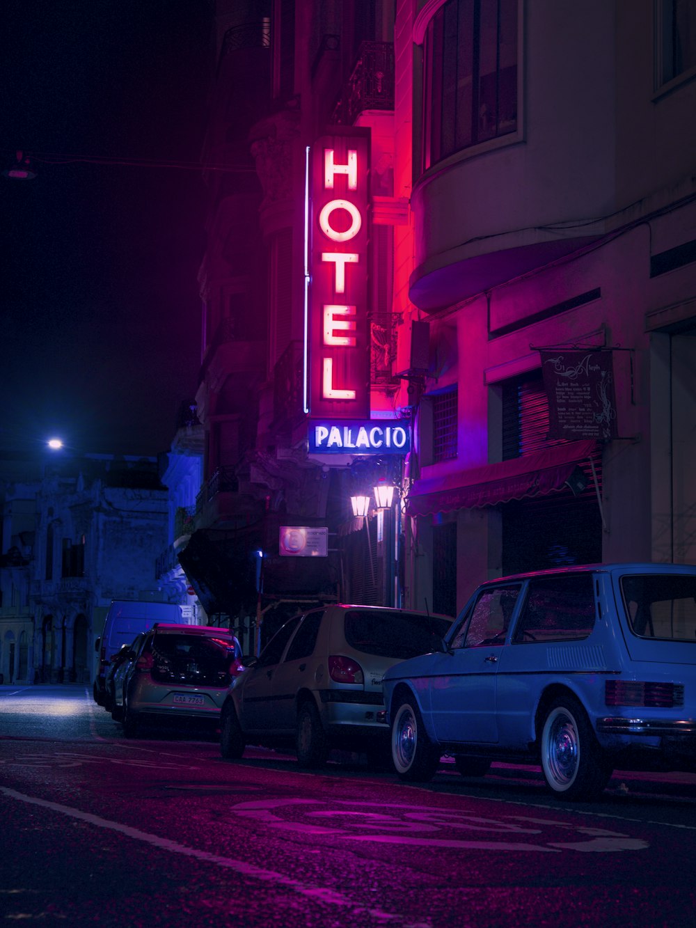 a neon hotel sign lit up at night