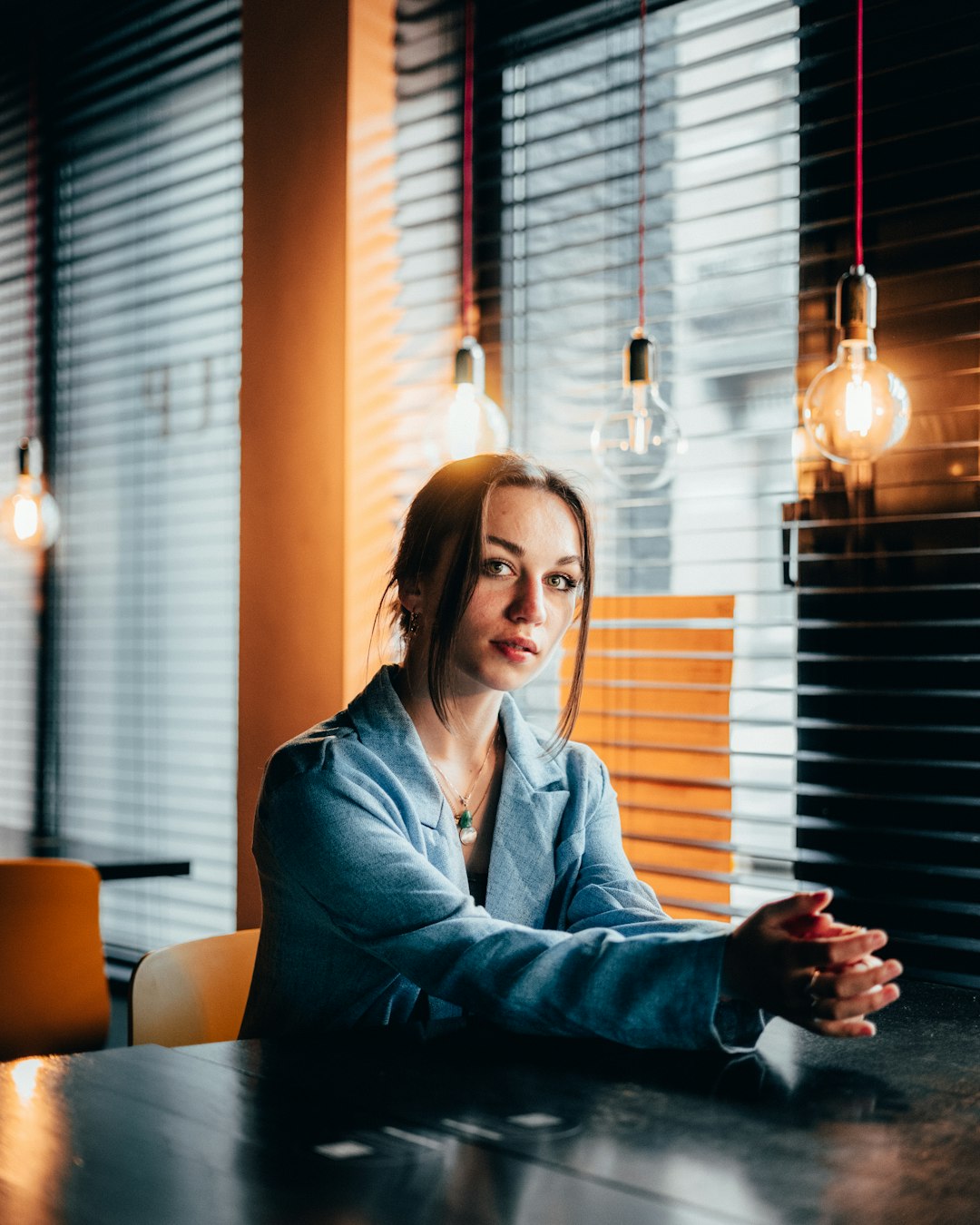 woman in blue jacket holding black ceramic mug