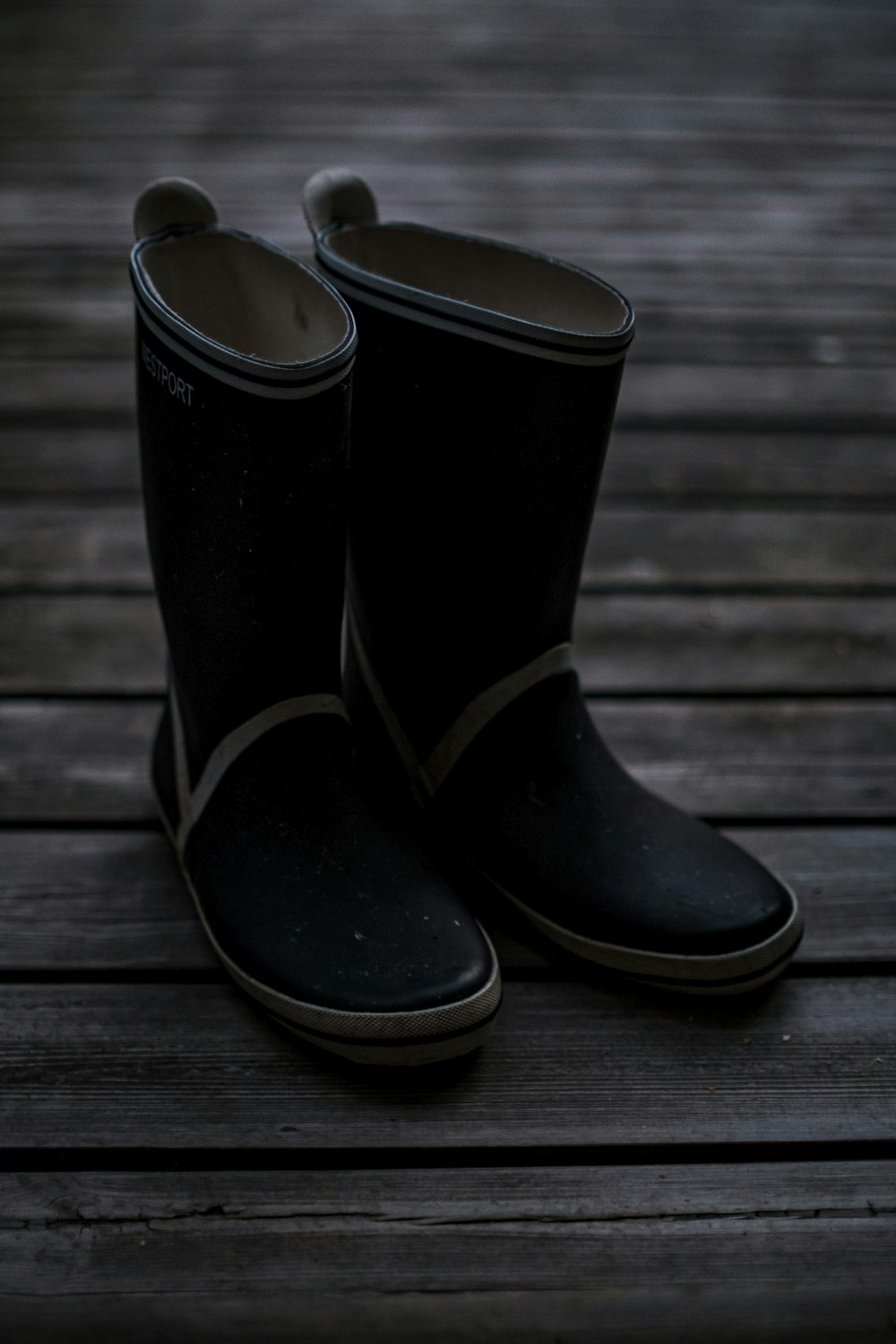 black and white leather boots on brown wooden floor