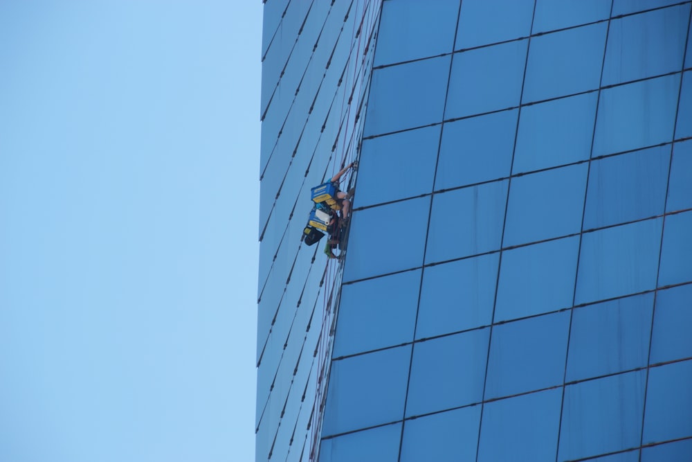 黄色いジャケットと黒いズボンを着た男が建物の屋上に立つ