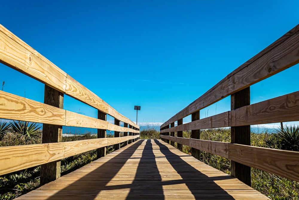 brown wooden bridge under blue sky during daytime