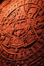 Close-up of an ancient calendar stone with intricate Aztec symbols engraved.