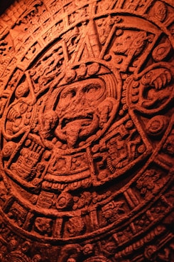 Close-up of an ancient calendar stone with intricate Aztec symbols engraved.