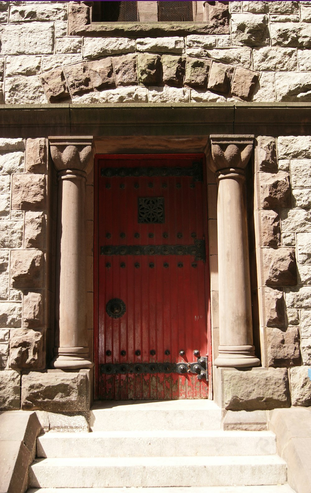red wooden door on brown concrete wall