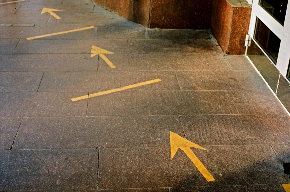 black and white arrow sign on gray concrete floor