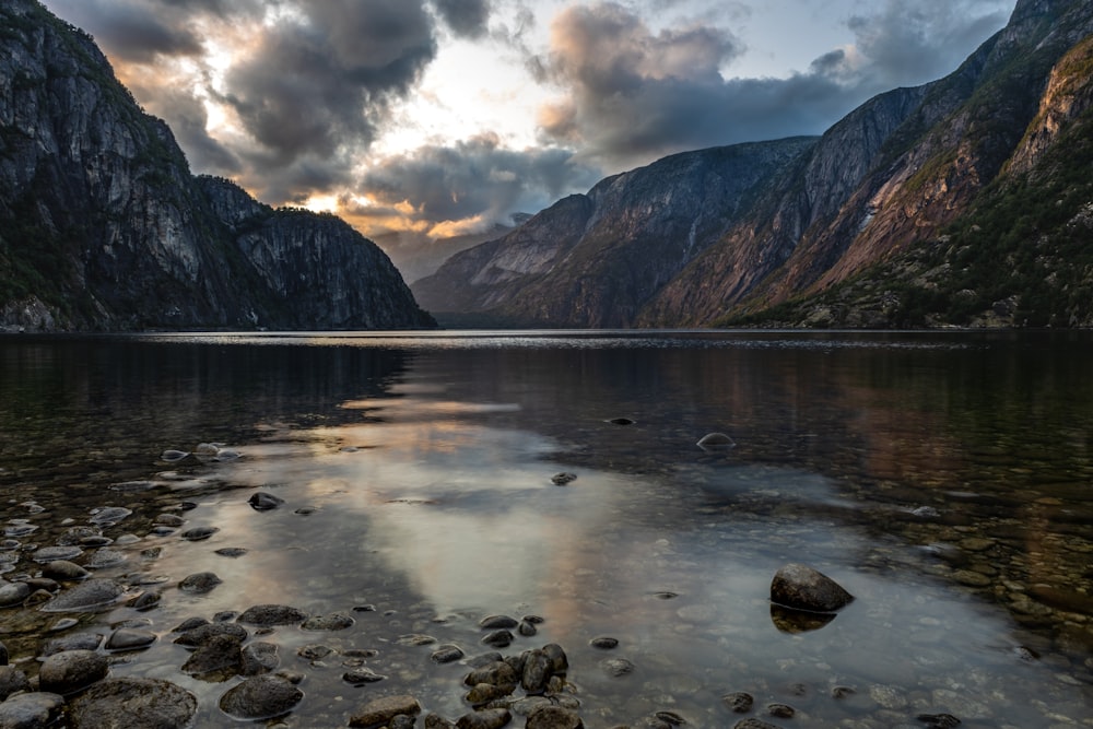 body of water near mountain during daytime