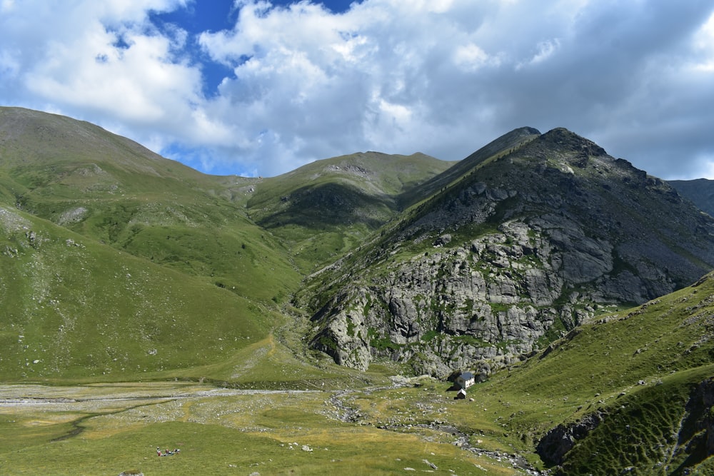 montagnes vertes et grises sous le ciel bleu pendant la journée