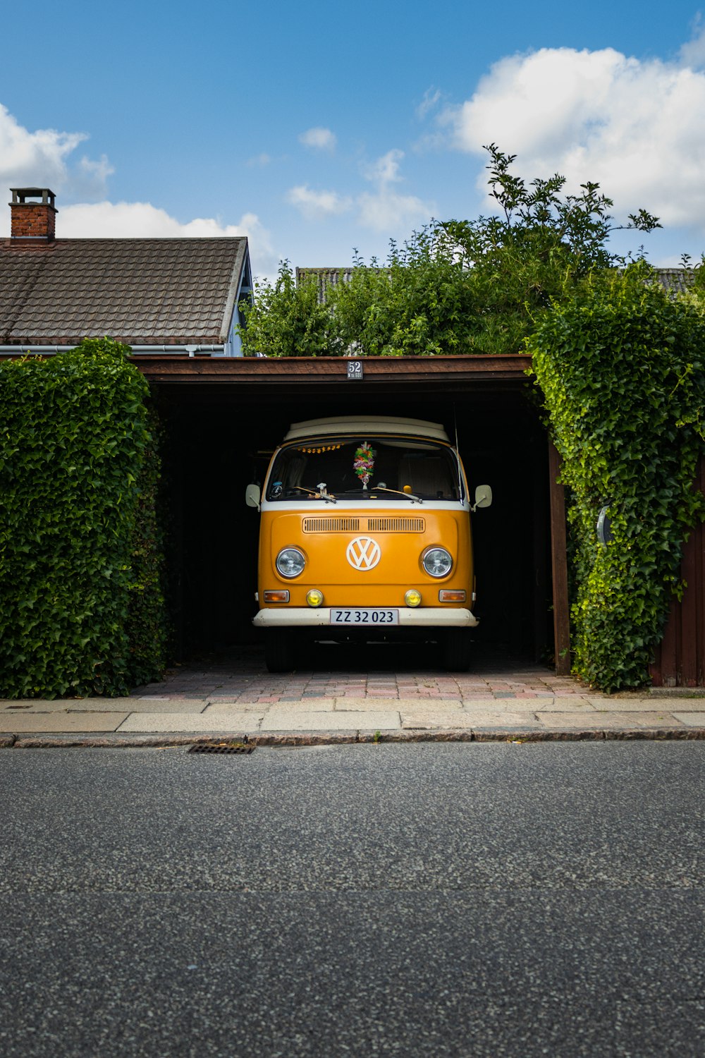 Volkswagen T-2 amarillo y negro aparcado junto a plantas verdes durante el día