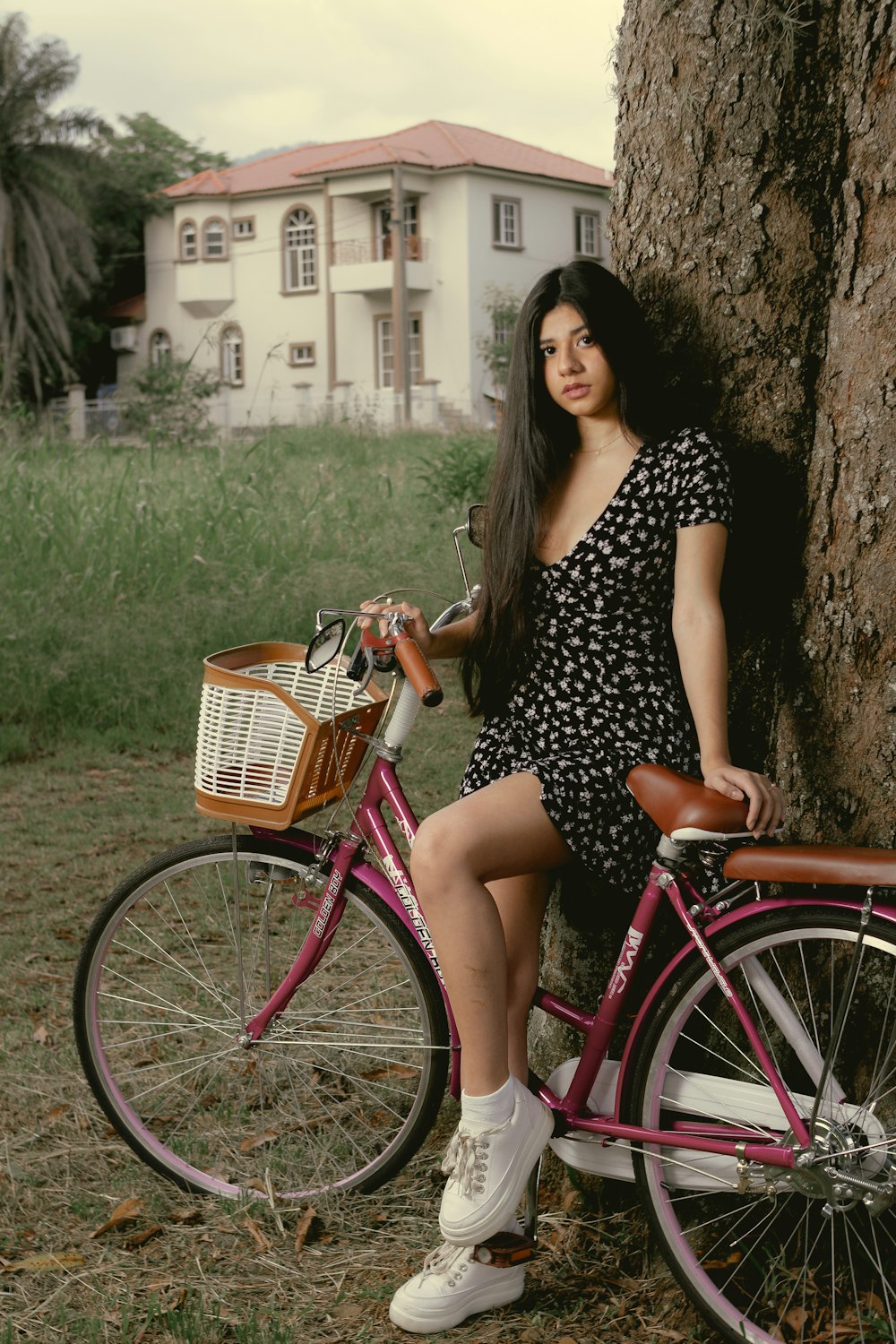 woman in black and white polka dot dress sitting on red bicycle