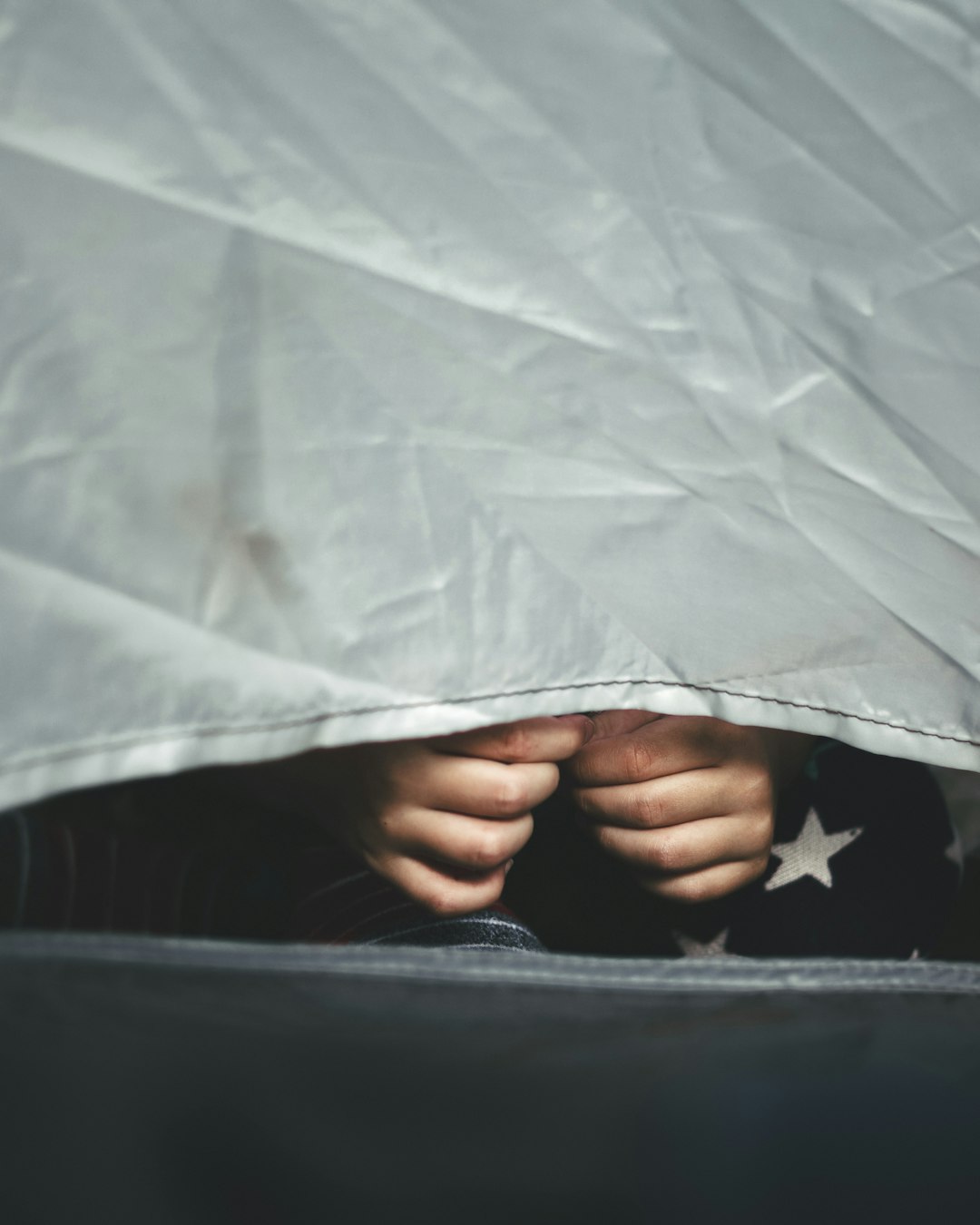 person holding white textile on black textile