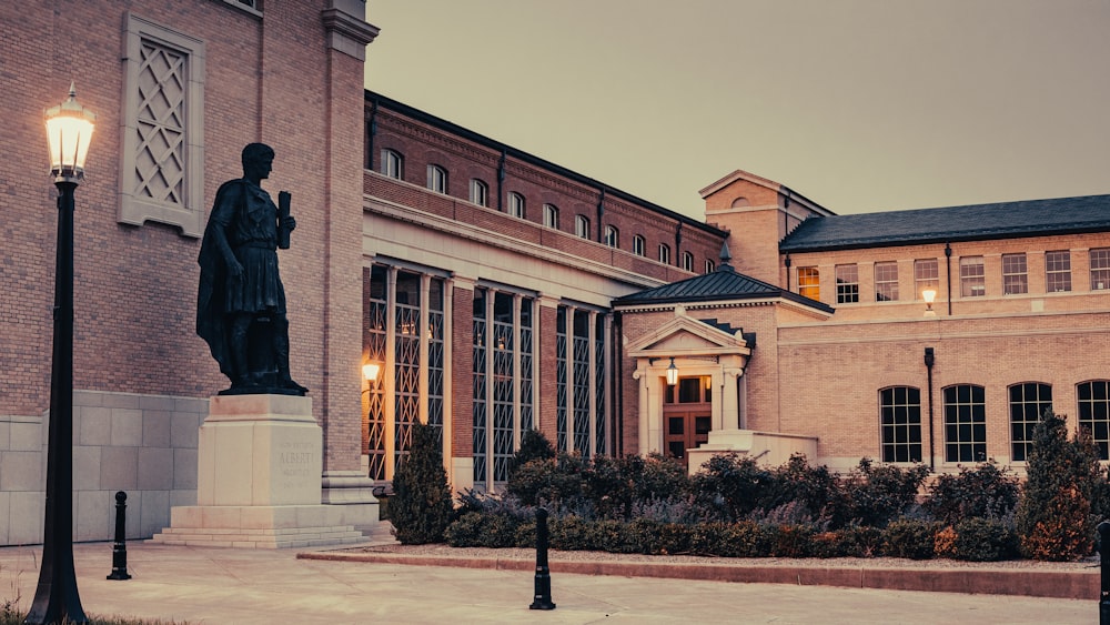 black statue in front of brown building