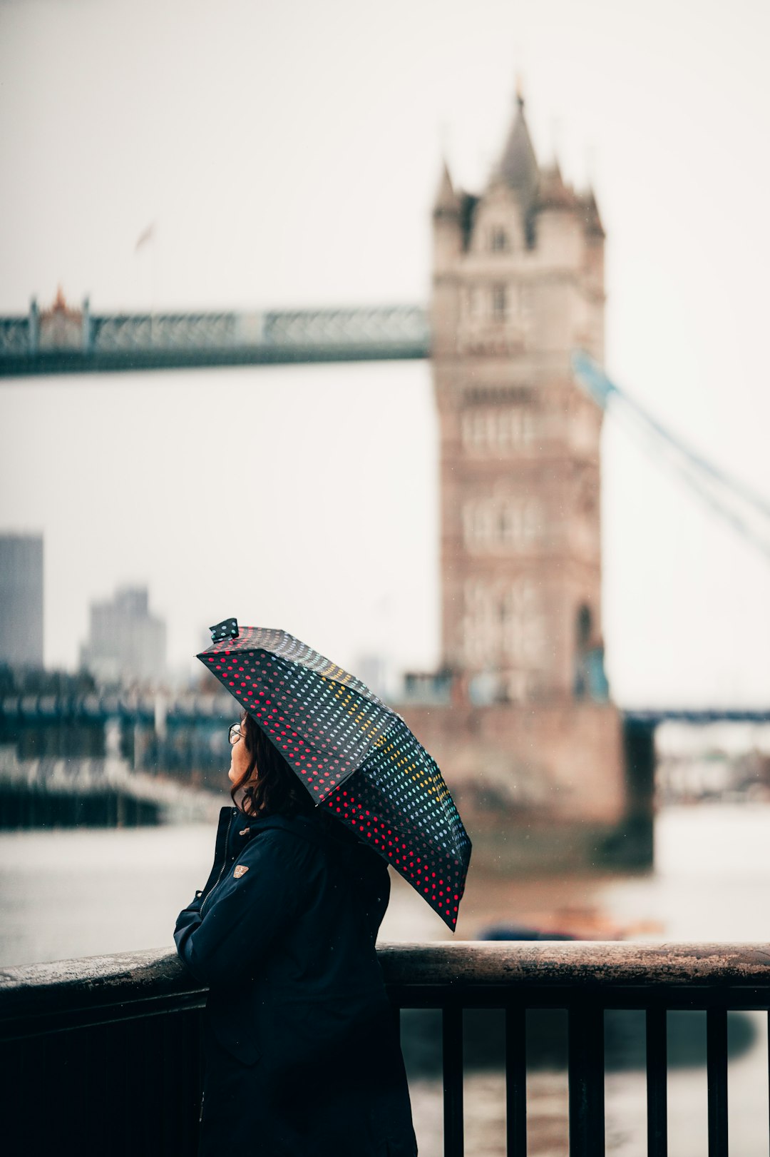 woman in black jacket holding red and white umbrella