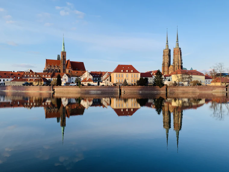 Riverside buildings in Wrocław reflected in the water