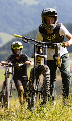 man in white shirt riding black mountain bike during daytime