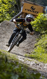 Cyclist geared up with protective elbow and back braces on a mountain path.