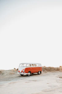 A warm photo of Eva and Andrés smiling beside their blue kombi van on a sunny day.