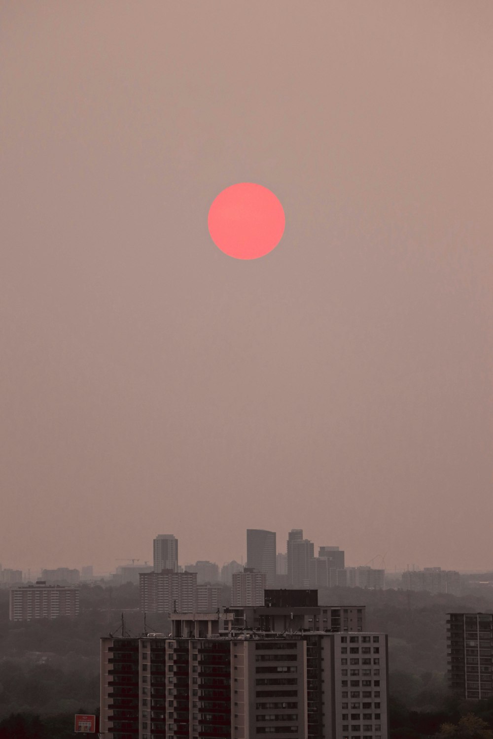 horizonte da cidade durante o pôr do sol com lua vermelha