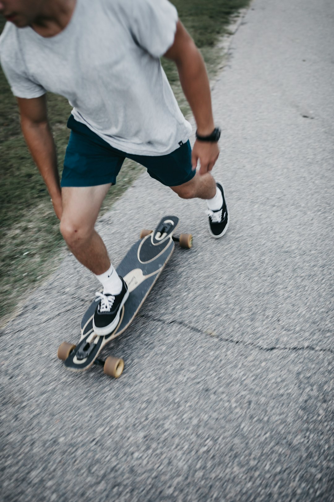 man in white t-shirt and blue shorts wearing black and white nike shoes