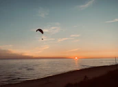 Panoramic view of the Ölüdeniz beach with paragliders in the sky at sunset.