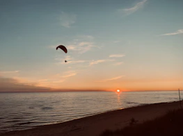 Panoramic view of the Ölüdeniz beach with paragliders in the sky at sunset.