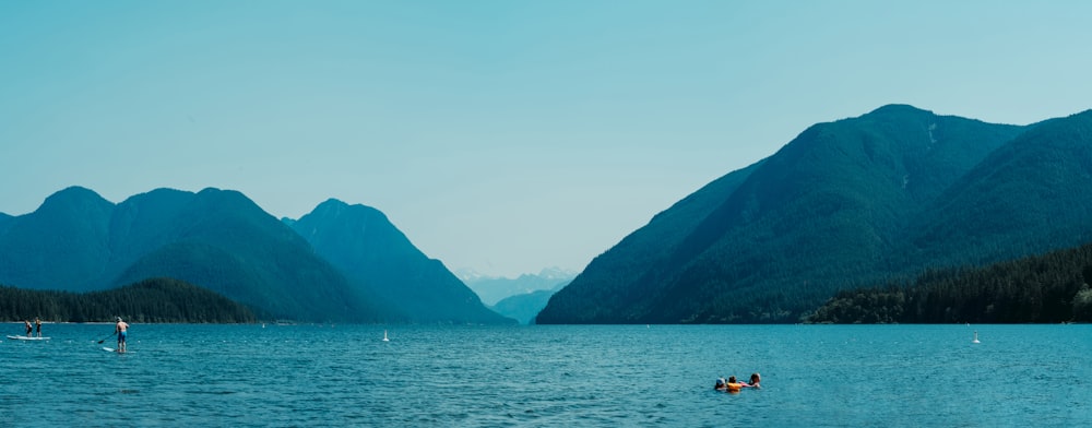 2 people riding on boat on sea near mountain during daytime