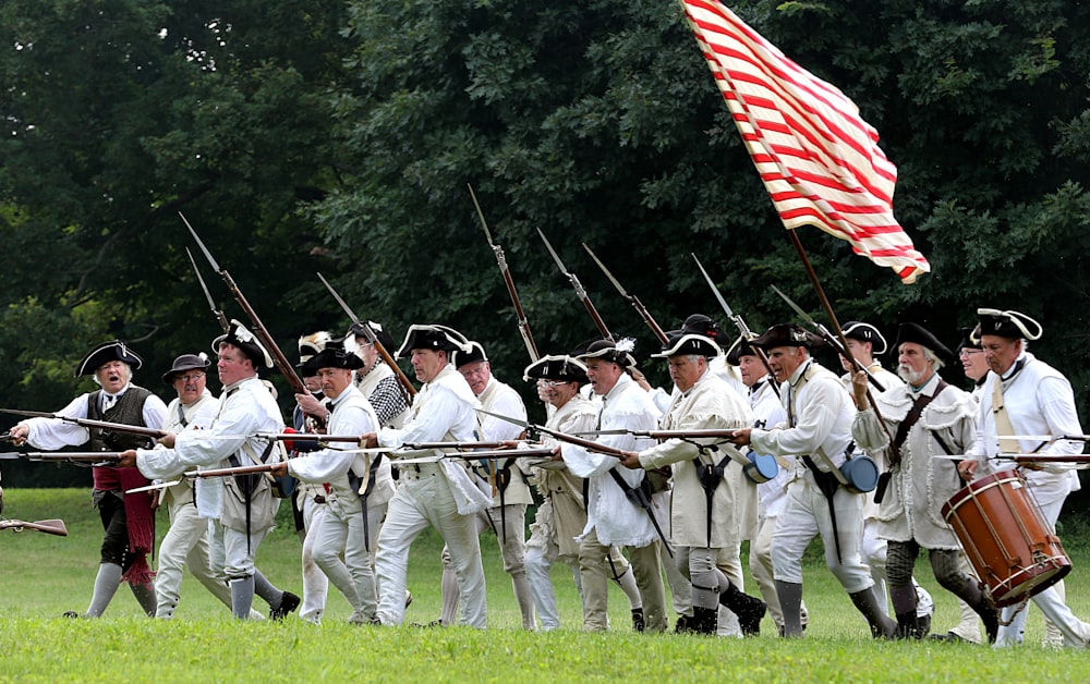 Hombres con camisa a rayas blancas y rojas sosteniendo banderas
