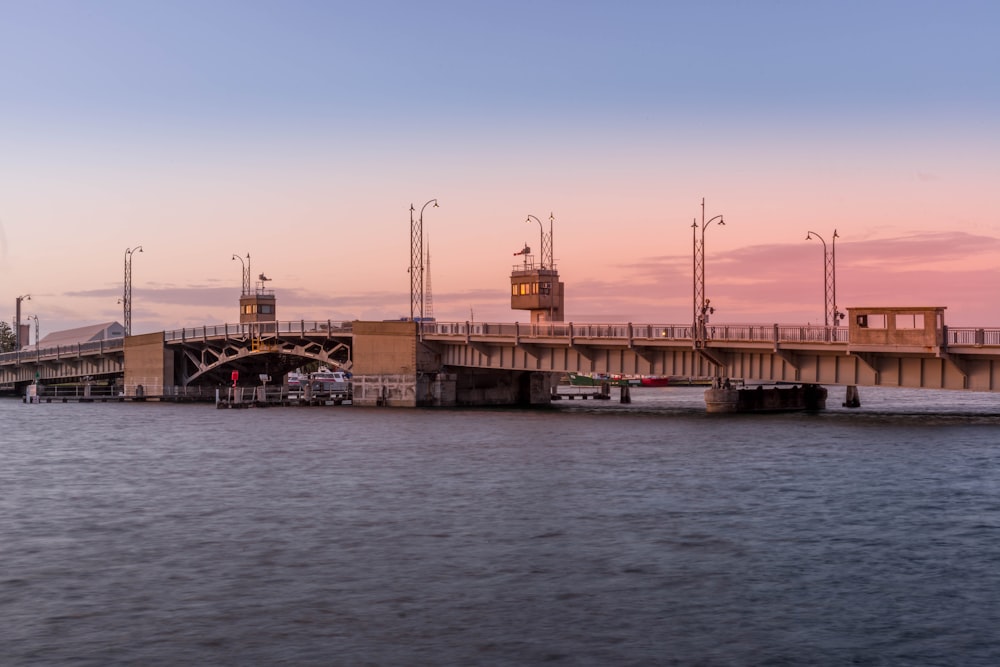 brown and white concrete bridge over body of water during daytime