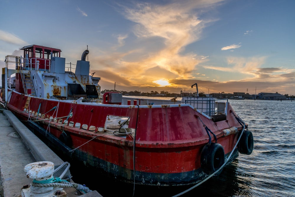 red and white boat on water during sunset