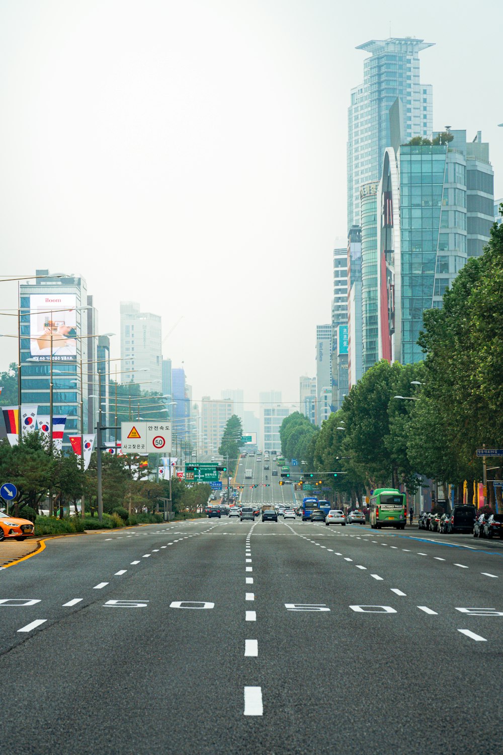 cars on road near high rise buildings during daytime