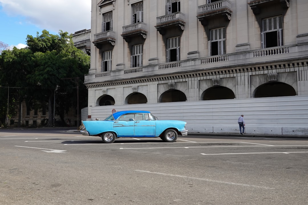 blue and white vintage car on road near building during daytime