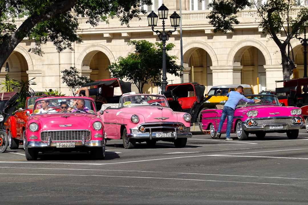 pink and purple vintage car on road during daytime