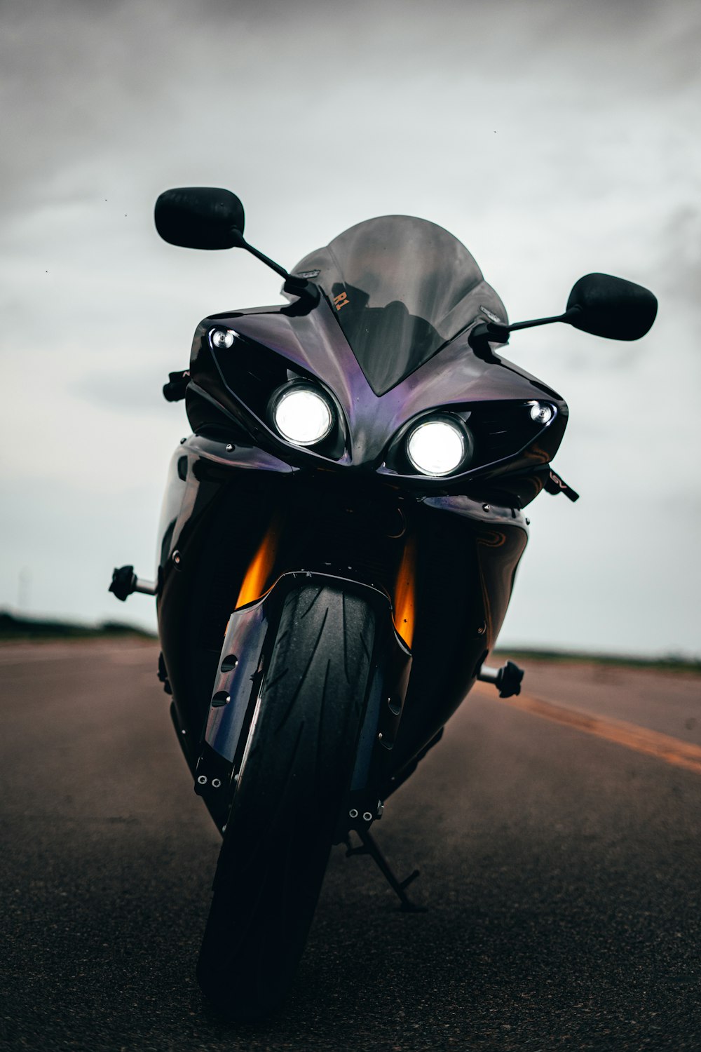 motocicleta preta e cinza na estrada durante o dia