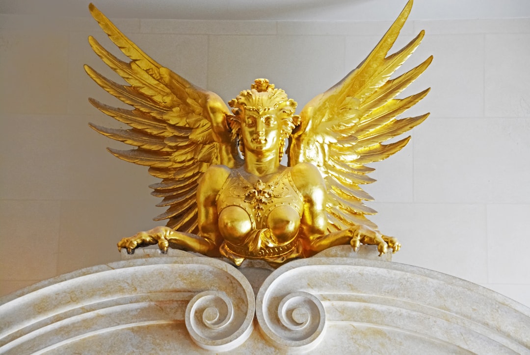 gold angel statue on white concrete surface