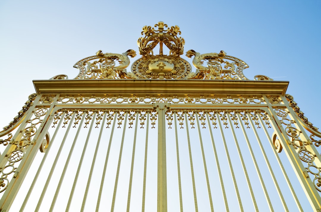 gold metal gate under blue sky during daytime