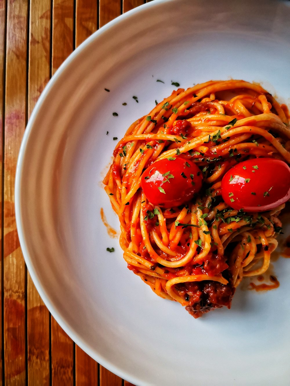 ein weißer Teller mit Spaghetti und Tomaten