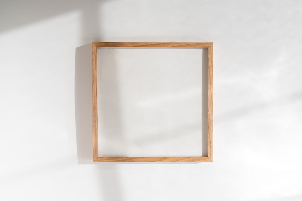 un cadre carré en bois accroché à un mur