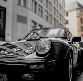 black porsche 911 parked near building during daytime