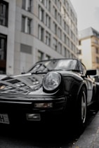 black porsche 911 parked near building during daytime