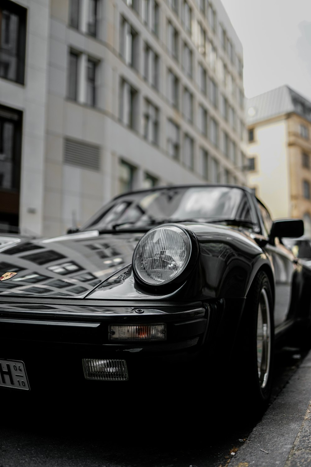 Porsche 911 preto estacionado perto do edifício durante o dia