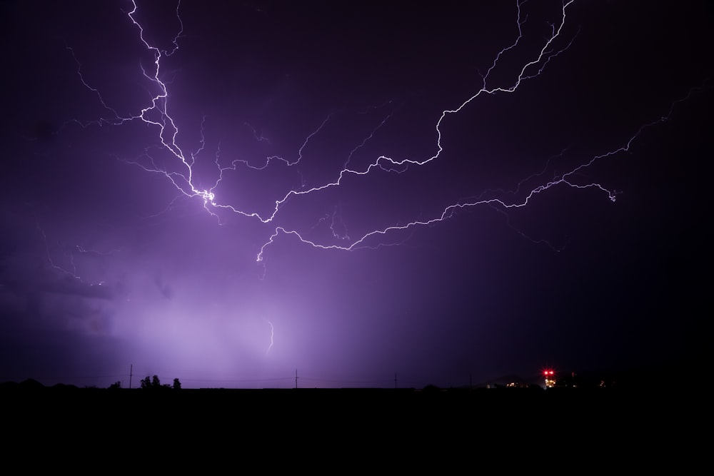 a lightning storm is seen over a city at night