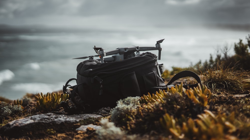 black leather backpack on rocky shore during daytime