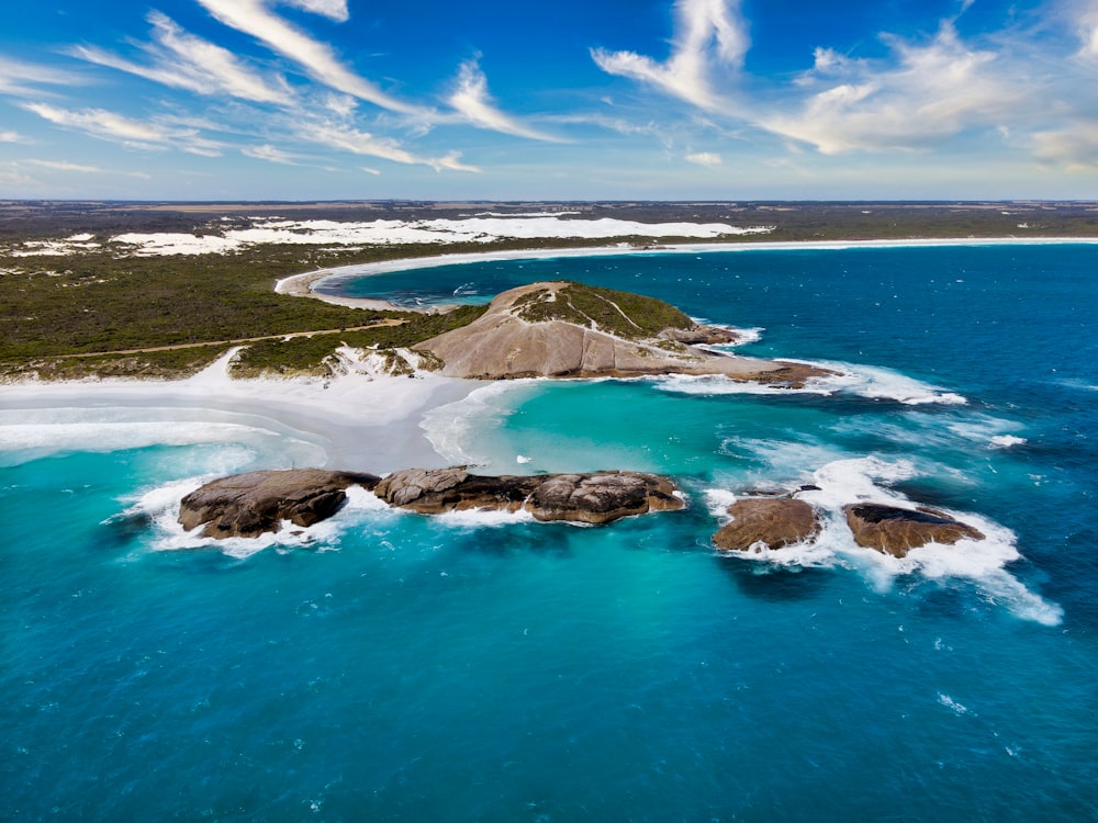 brown and green island on blue sea under blue sky during daytime