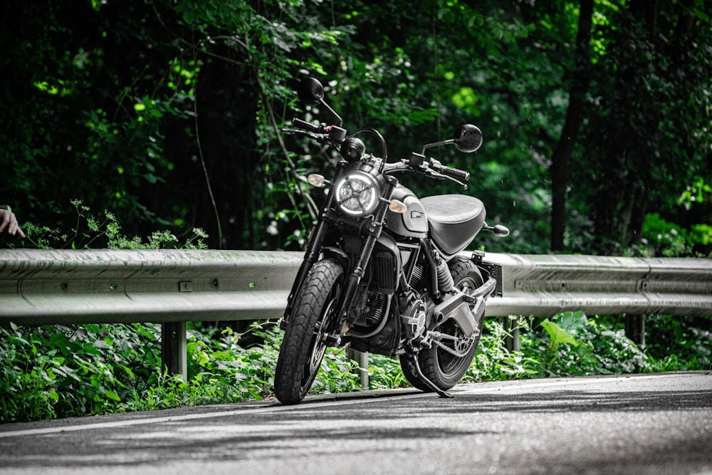 black motorcycle parked on road during daytime