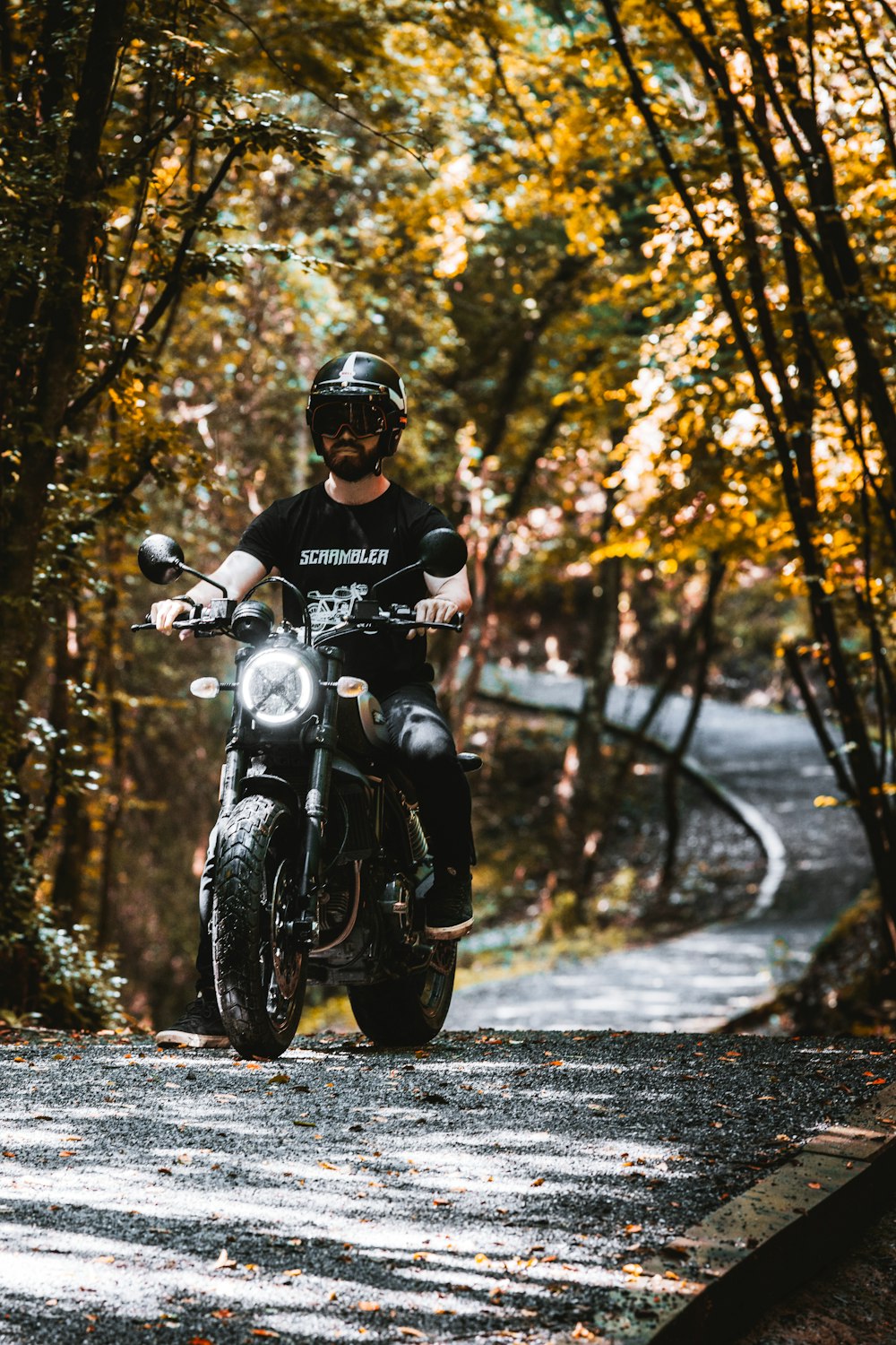 man in black helmet riding black motorcycle on road during daytime