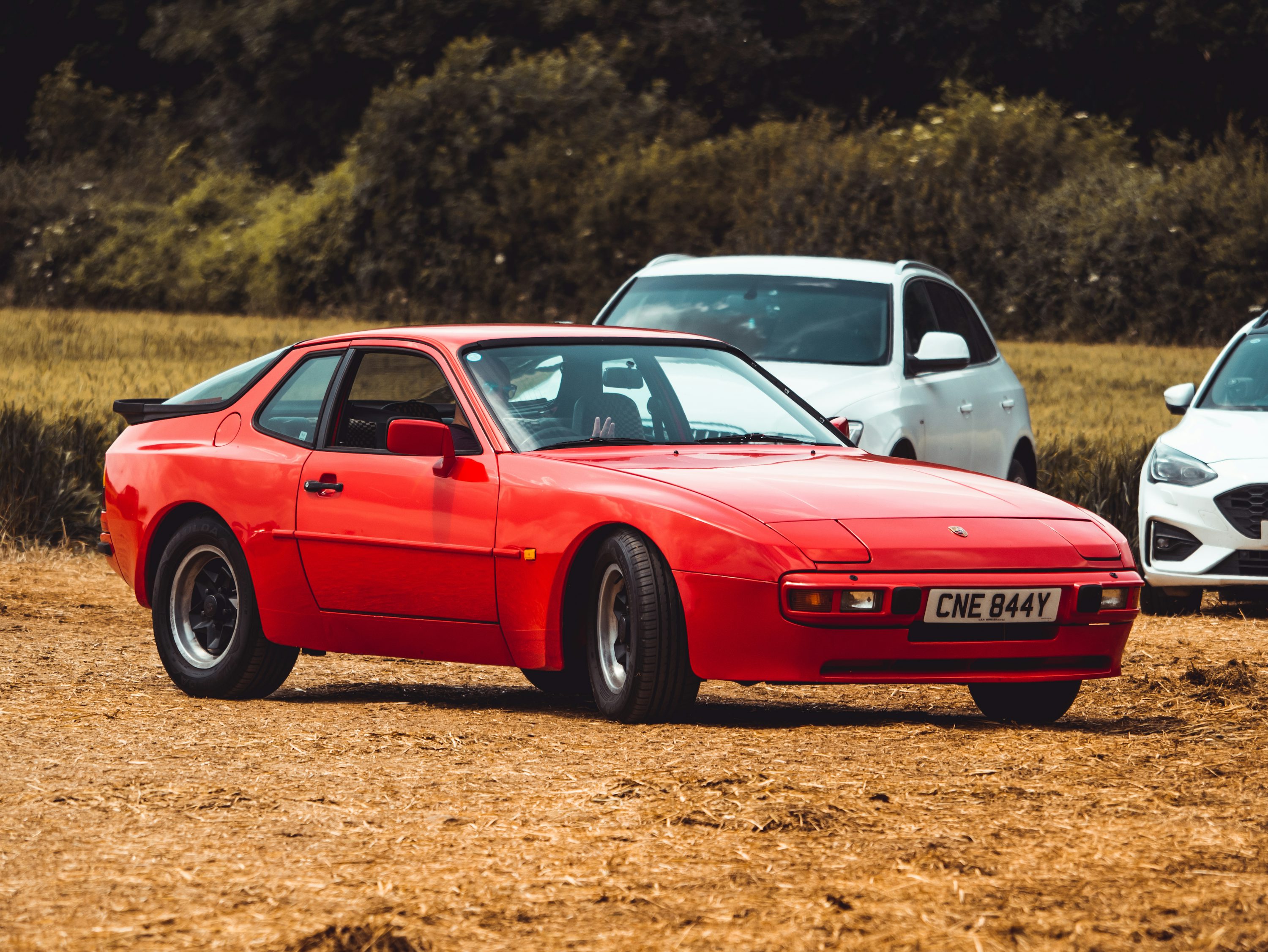 red porsche 911 on brown field during daytime