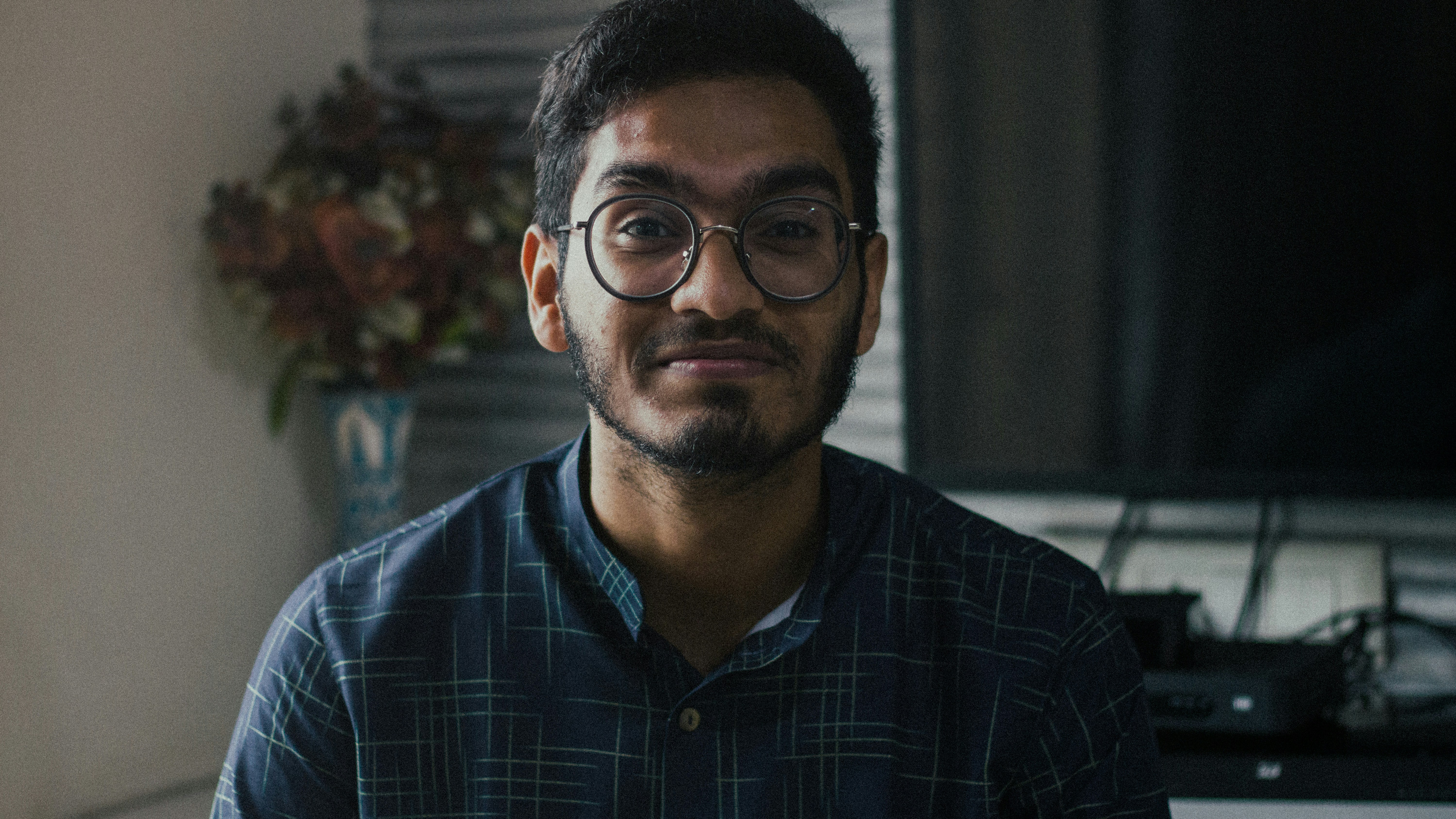 man in blue and white plaid button up shirt wearing black framed eyeglasses
