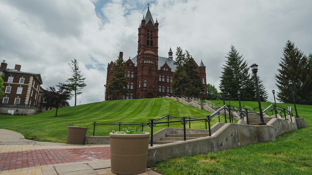brown concrete building near green grass field under cloudy sky during daytime