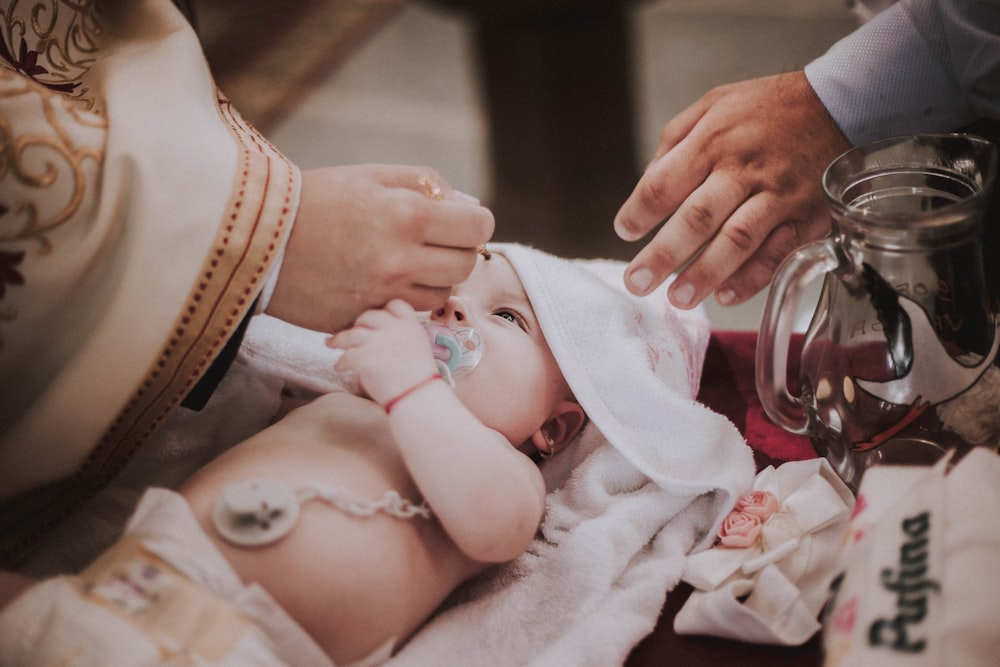 person holding baby on bed