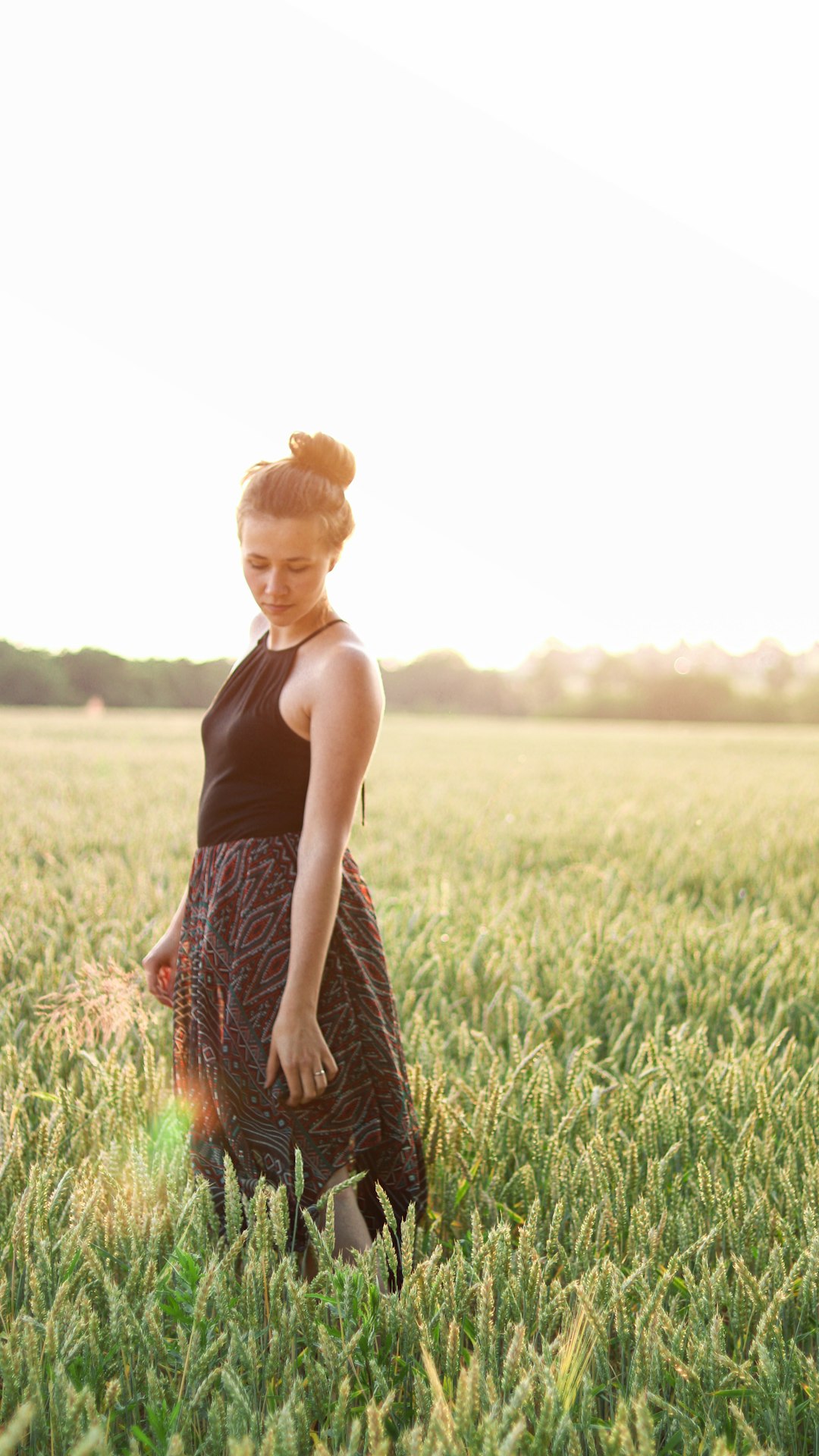 woman in black tank top standing on green grass field during daytime